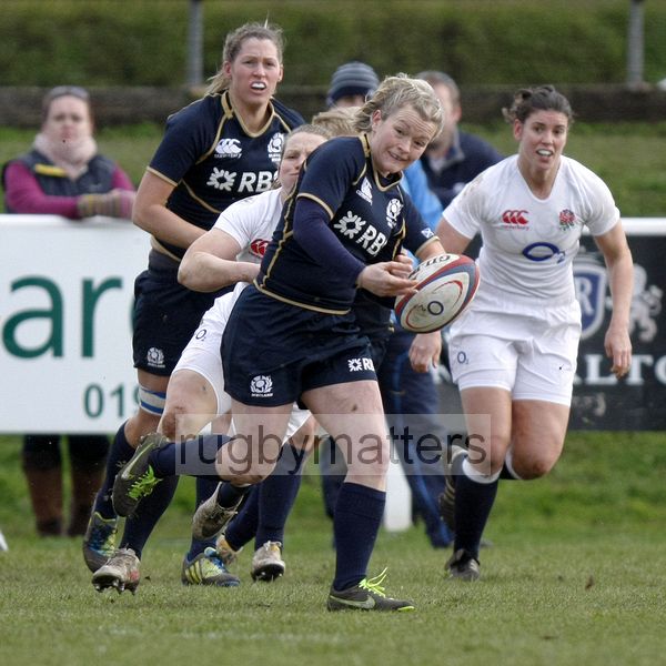 Louise Dalglish looks to pass the ball as Hannah Gallagher closes in to tackle her. England Women v Scotland Women at Esher RFC on 2nd February 2013.